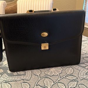 Black leather briefcase designed 3 zippered inside pockets 4 file pockets.